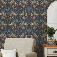 a living room with a chair, mirror and wallpaper design on the wall behind it