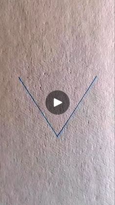 a white wall with an arrow drawn on it and a video playing button in the middle