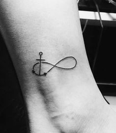 an anchor tattoo on the ankle that is connected to a cross and has a hook in it