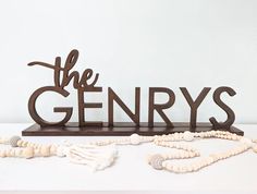 a wooden sign that says the genry's on top of a white table