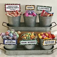 several buckets filled with different types of candy and candies sitting on top of a metal tray