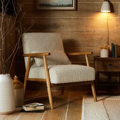 a chair and table in a room with wood paneling on the wall behind it