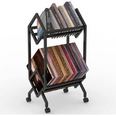 a book rack with several books on it and wheels holding magazines in different colors, shapes and sizes