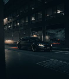 a black car is parked on the street at night