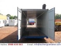 the back end of a truck with it's door open on dirt ground next to other trucks