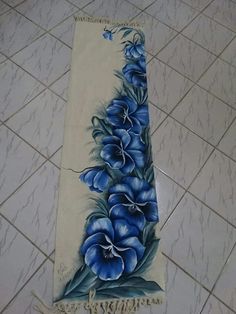 a towel with blue flowers on it sitting on the floor next to a tile floor