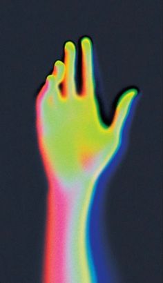 a person's hand is shown with colored light on it