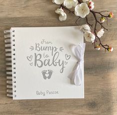 a baby's book with the words bump to baby written on it next to flowers