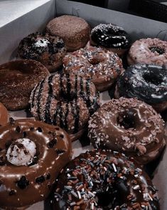 a box filled with lots of different flavored donuts