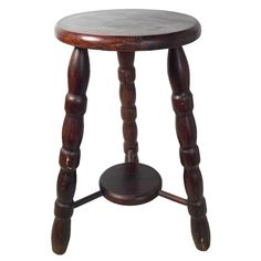 an old wooden stool with two legs and a small round table on one end that is turned upside down