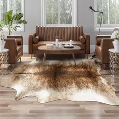 a living room filled with furniture and a cow skin rug