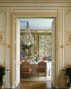 two chairs sitting in front of a table with a chandelier