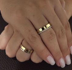 two hands with wedding rings on them, one is holding the other's hand