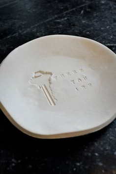 a white plate with the words happy new year on it sitting on a black table