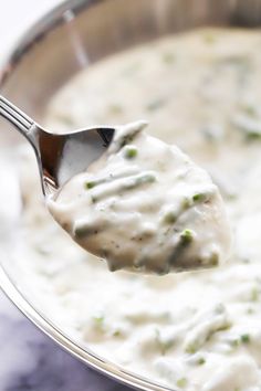 a spoon full of white sauce with green sprinkles