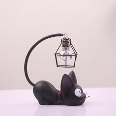 a black cat lamp with a light bulb on it's head