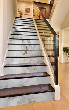 a staircase with marble steps leading up to the second floor