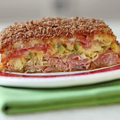 a plate with a sandwich on top of it next to green napkins and fork