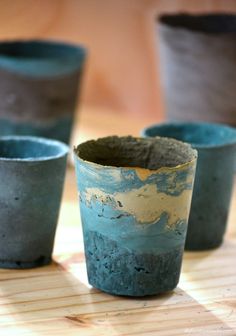 four pots sitting on top of a wooden table