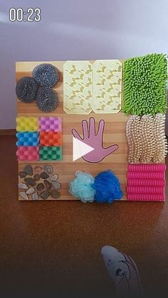 an art project made out of legos on a wooden board with colored blocks and shapes