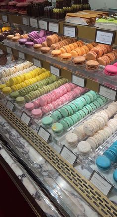 a display case filled with lots of different colored donuts