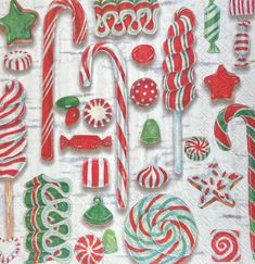 an assortment of candy canes, candies and lollipops on a napkin