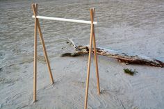 two sticks sticking out of the sand next to a log