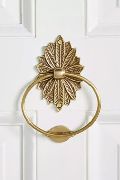 a gold metal door handle with a leaf design on the front and back of it