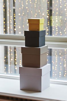 a stack of boxes sitting on top of a window sill