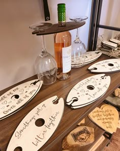 wine glasses and personalized wooden signs are on display at the table with other items