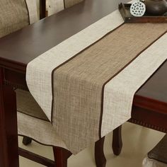 the table is set with a brown and white striped linen runner on top of it