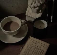 a cup of coffee next to an old book