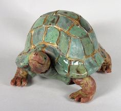 a ceramic turtle sitting on top of a white table