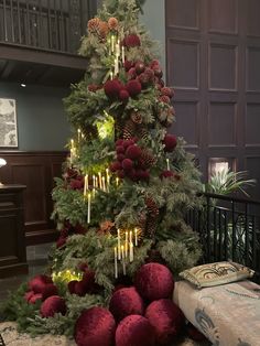 a christmas tree decorated with red balls and pine cones