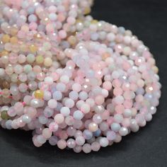 some white and pink beads on a black surface