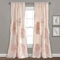 the curtains in this room are pink and have white flowers on them, while the window is