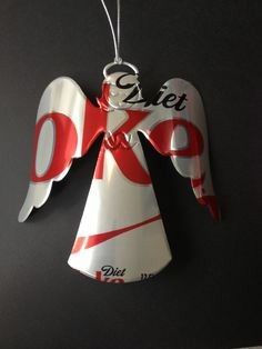 an ornament hanging from the side of a wall with a coca cola angel on it