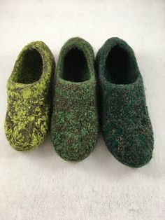 three pairs of slippers sitting on top of a white surface