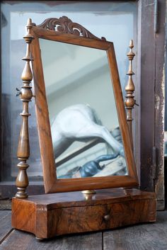 an old wooden stand with a mirror on it