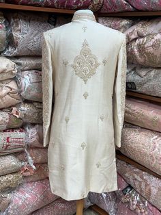 This beige white royal sherwani is brought into limelight with fine jaal embroidered coat enhanced with resham, pearl ,stone & cut dana work. The coat is styled with matching churidar pants. Size:40,42,44 Occasion: Wedding Ceremony or Reception WASH CARE INSTRUCTIONS - Please Dry clean only when it is applicable. Slight color variation is possible due to digital photography. Ready to Ship! Elegant Semi-stitched Raw Silk Sherwani, Elegant Raw Silk Sherwani With Intricate Embroidery, Elegant Jamawar Sherwani With Intricate Embroidery, Elegant Sherwani With Intricate Embroidery In Jamawar, Semi-stitched Raw Silk Sherwani With Intricate Embroidery, Long Kurta With Dabka Work For Wedding, Elegant Semi-stitched Sherwani With Dabka Work, Long Wedding Kurta With Dabka Work, Elegant Sherwani In Raw Silk With Straight Kurta