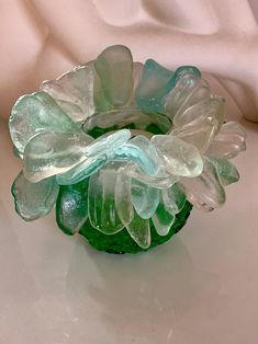 a green glass vase sitting on top of a white table