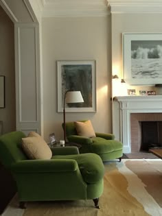 a living room filled with furniture and a fire place under a painting on the wall