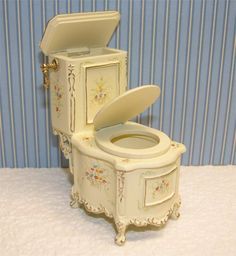 a white toilet sitting on top of a table next to a blue striped wallpaper