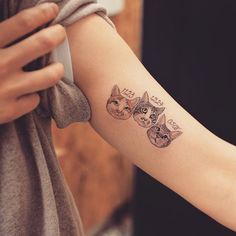 a woman's arm with three cats on it and the word love written in cursive writing