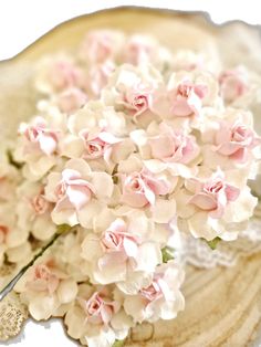 a bouquet of pink and white flowers sitting on top of a piece of paper with scissors