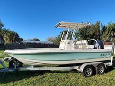 a white boat is parked on the grass