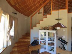 there is a room with wooden stairs and bookshelves