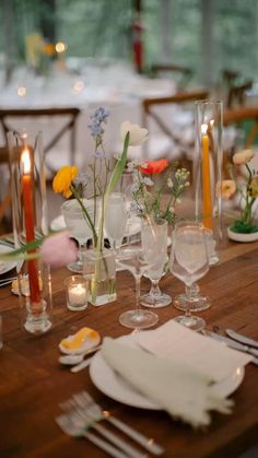 a wooden table topped with lots of plates and glasses