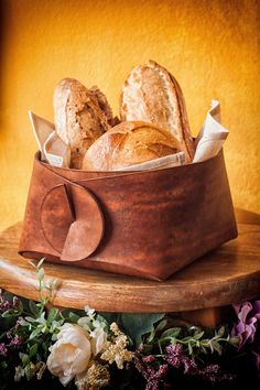 bread in a leather basket on a wooden table