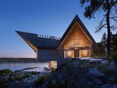 a house on the edge of a body of water at night with its roof lit up